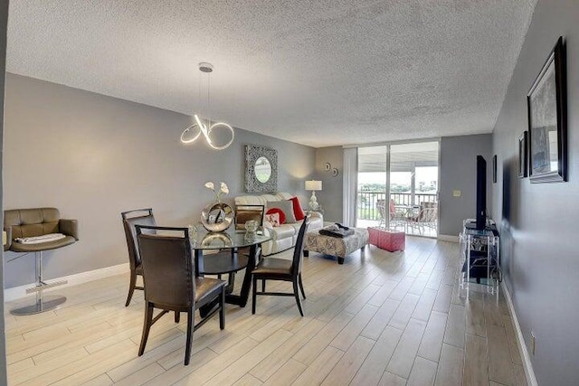 14723 Cumberland Dr Unit 406, Delray Beach, FL 33446 - dining area featuring a textured ceiling, light wood-style floors, baseboards, expansive windows, and a chandelier