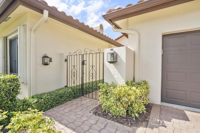 22652 Esplanada Cir W, Boca Raton, FL 33433 - view of exterior entry featuring stucco siding, a gate, and a tiled roof
