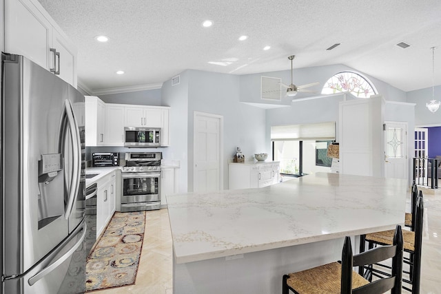 22652 Esplanada Cir W, Boca Raton, FL 33433 - kitchen featuring stainless steel appliances, vaulted ceiling, ceiling fan, a breakfast bar, and white cabinetry