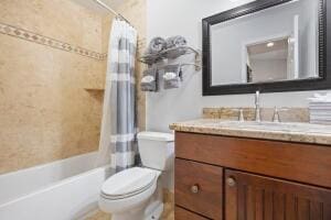 full bath featuring toilet, vanity, and shower / bath combination with curtain