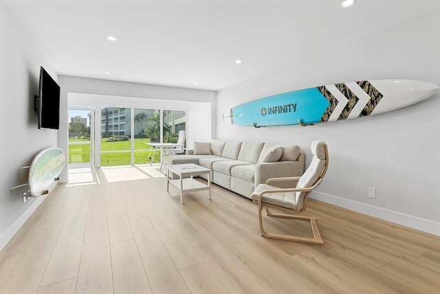 living area featuring recessed lighting, baseboards, and wood finished floors