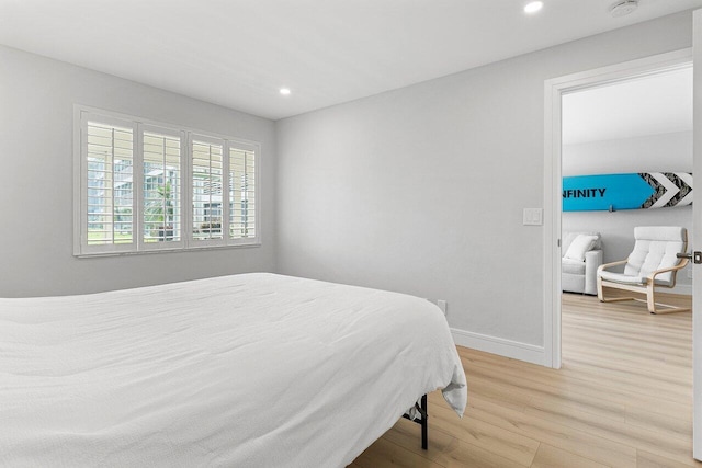 bedroom with recessed lighting, light wood-style flooring, and baseboards