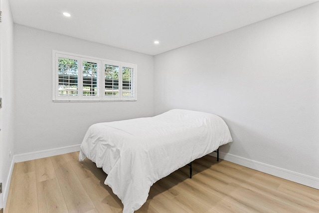 bedroom featuring wood finished floors, baseboards, and recessed lighting