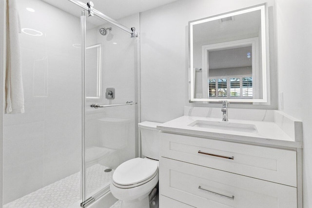 bathroom with a shower stall, vanity, visible vents, and toilet