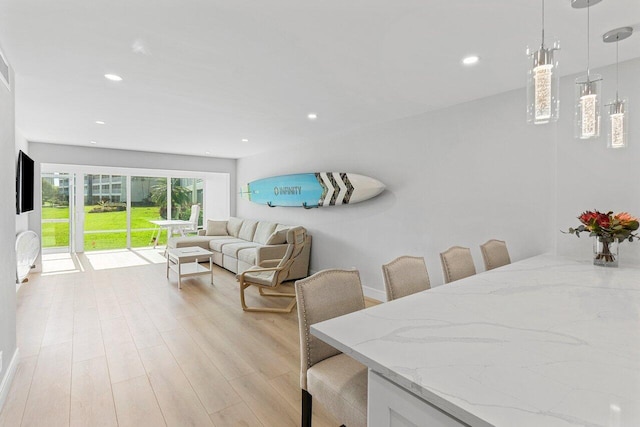 dining room with light wood finished floors, baseboards, and recessed lighting