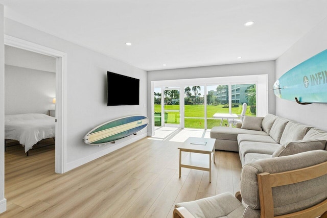 living area with baseboards, recessed lighting, and light wood-style floors