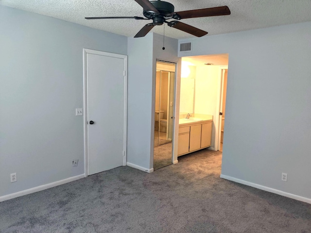 701 Sabal Ridge Cir Unit C, Palm Beach Gardens, FL 33418 - unfurnished bedroom featuring carpet flooring, a sink, a textured ceiling, baseboards, and ensuite bath