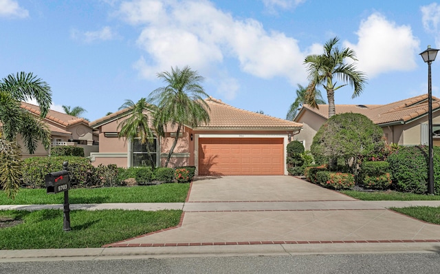mediterranean / spanish-style house with a front lawn, a tiled roof, driveway, an attached garage, and stucco siding