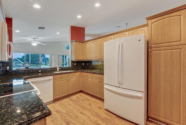 kitchen with white appliances, a sink, backsplash, and light brown cabinetry