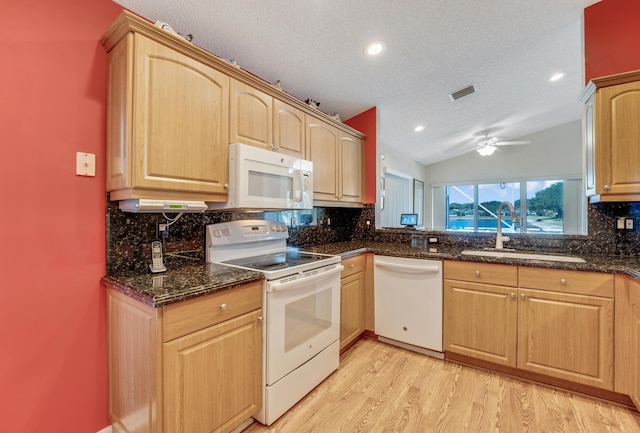 kitchen featuring a ceiling fan, a sink, decorative backsplash, white appliances, and light wood finished floors