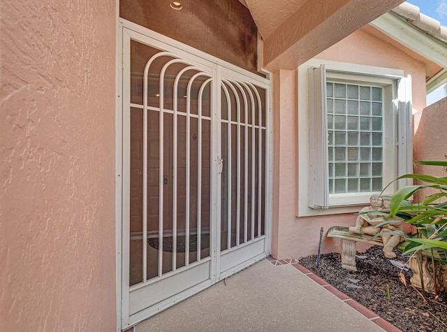 entrance to property featuring stucco siding