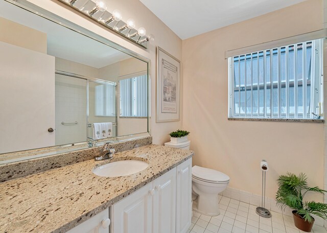 full bathroom featuring tile patterned flooring, a shower with door, toilet, vanity, and baseboards