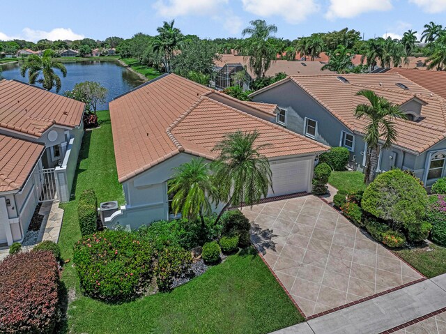 9703 Harbour Lake Cir, Boynton Beach, FL 33437 - view of front of house with driveway, a tiled roof, a garage, stucco siding, and a front yard