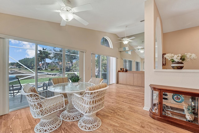 dining area with wood finished floors, high vaulted ceiling, and ceiling fan