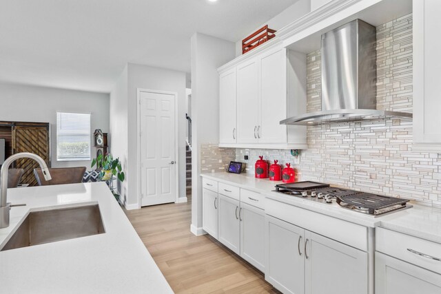 1104 Wandering Willow Way, Loxahatchee, FL 33470 - kitchen with wall chimney range hood, stainless steel gas stovetop, decorative backsplash, and a sink