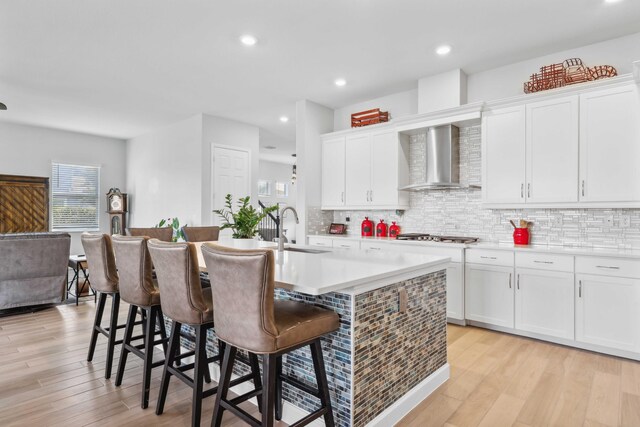1104 Wandering Willow Way, Loxahatchee, FL 33470 - kitchen featuring a center island with sink, a sink, wall chimney exhaust hood, and plenty of natural light