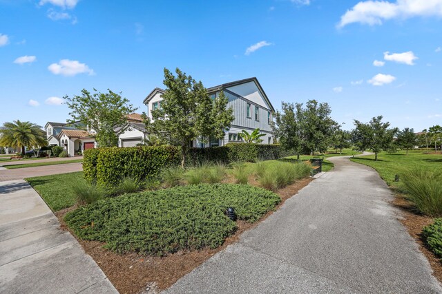 1104 Wandering Willow Way, Loxahatchee, FL 33470 - view of side of home featuring a lawn and driveway