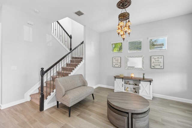 1104 Wandering Willow Way, Loxahatchee, FL 33470 - sitting room featuring visible vents, light wood-type flooring, baseboards, a chandelier, and stairs