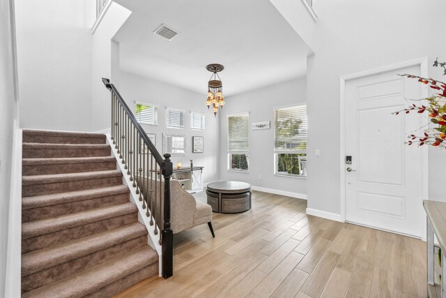1104 Wandering Willow Way, Loxahatchee, FL 33470 - foyer with a chandelier, stairs, baseboards, light wood-type flooring, and visible vents