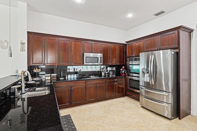 1070 Grove Park Cir, Boynton Beach, FL 33436 - kitchen featuring stainless steel appliances, a sink, dark stone countertops, visible vents, and decorative backsplash