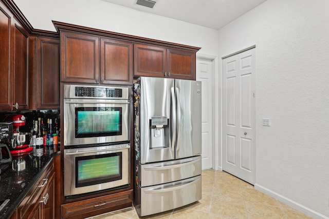 1070 Grove Park Cir, Boynton Beach, FL 33436 - kitchen featuring stainless steel appliances, visible vents, light tile patterned flooring, dark stone counters, and baseboards