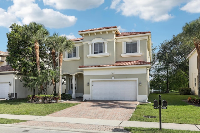 1070 Grove Park Cir, Boynton Beach, FL 33436 - mediterranean / spanish home with a tiled roof, a garage, a front yard, stucco siding, and decorative driveway