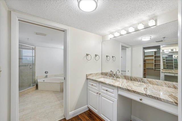 7572 Regency Lake Dr Unit 501, Boca Raton, FL 33433 - full bath with vanity, a bath, a shower stall, a textured ceiling, and baseboards