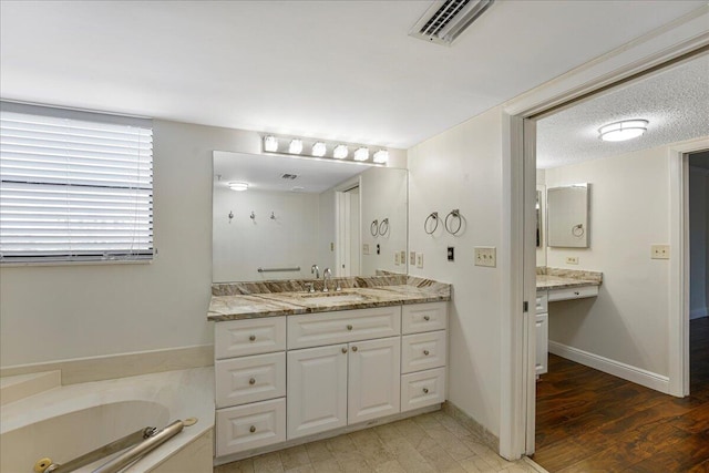 7572 Regency Lake Dr Unit 501, Boca Raton, FL 33433 - bathroom with vanity, a tub with jets, wood finished floors, and baseboards