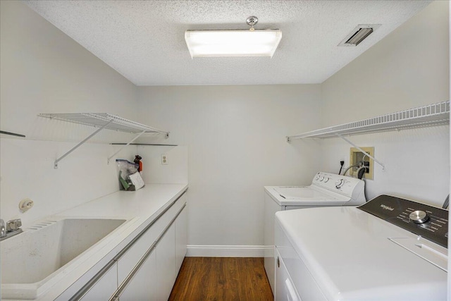 7572 Regency Lake Dr Unit 501, Boca Raton, FL 33433 - washroom featuring washing machine and clothes dryer, dark wood-type flooring, a textured ceiling, and baseboards