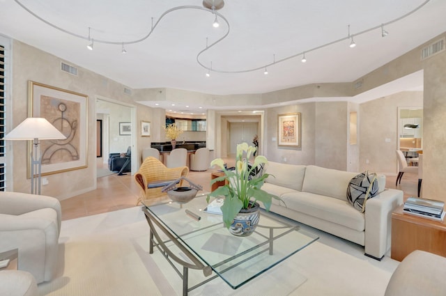 living room featuring light tile patterned floors, visible vents, and baseboards
