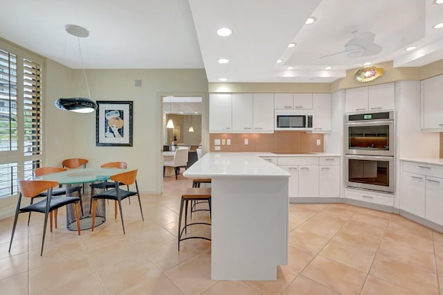 kitchen featuring a kitchen breakfast bar, double oven, and white cabinets