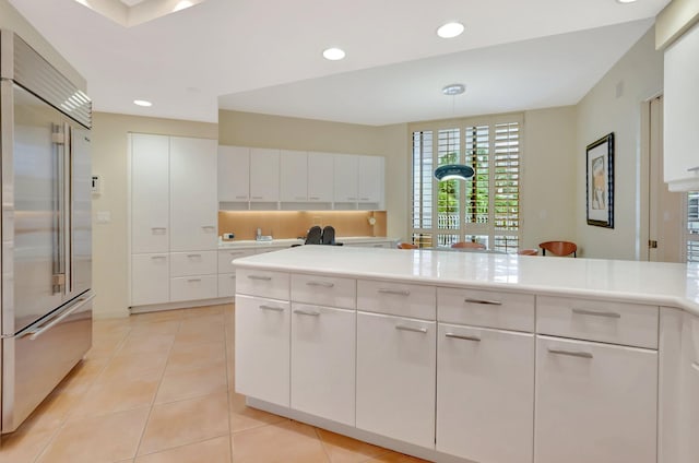 kitchen featuring white cabinets, light countertops, light tile patterned floors, and stainless steel built in refrigerator