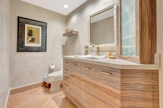 bathroom featuring tile patterned floors, toilet, baseboards, and vanity