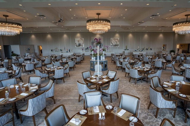 dining room with a raised ceiling, a chandelier, recessed lighting, and a towering ceiling