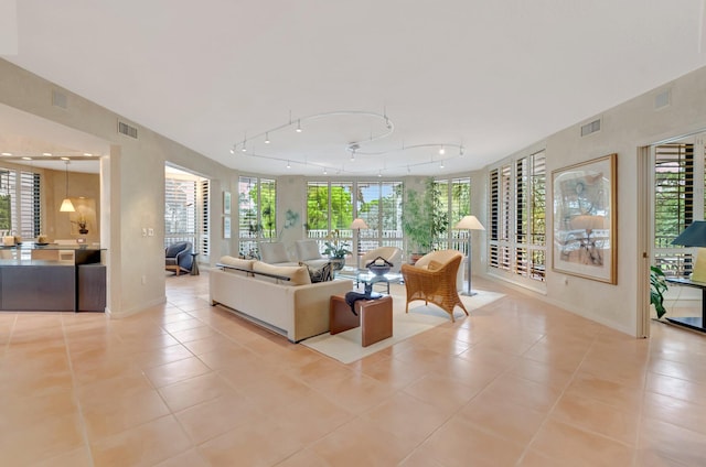 living room with a healthy amount of sunlight, tile patterned flooring, and visible vents