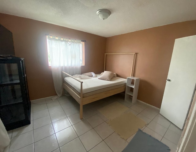 bedroom with a textured ceiling and light tile patterned floors