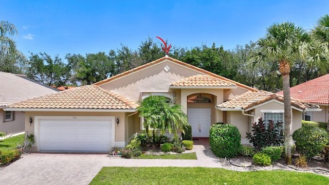 5266 Landon Cir, Boynton Beach, FL 33437 - mediterranean / spanish-style house featuring driveway, stucco siding, an attached garage, and a tile roof