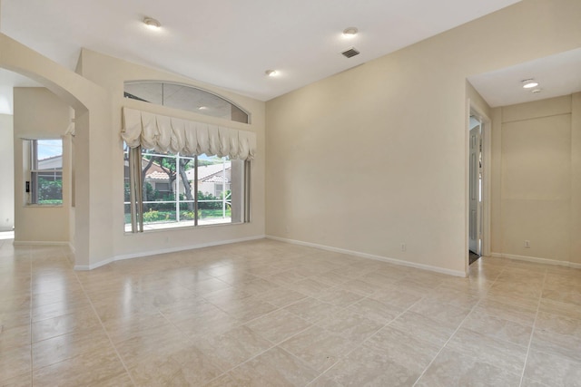 5266 Landon Cir, Boynton Beach, FL 33437 - unfurnished living room featuring arched walkways, baseboards, and light tile patterned flooring