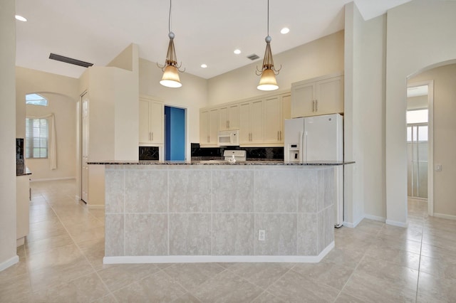 5266 Landon Cir, Boynton Beach, FL 33437 - kitchen featuring baseboards, dark stone countertops, white appliances, light tile patterned floors, and arched walkways