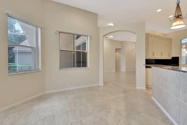 5266 Landon Cir, Boynton Beach, FL 33437 - unfurnished room featuring arched walkways, a healthy amount of sunlight, and baseboards