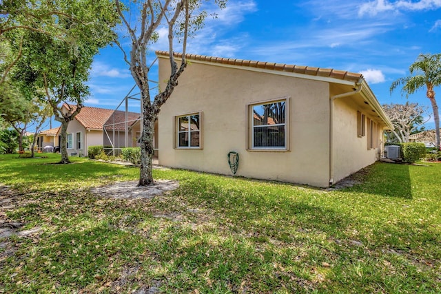 5266 Landon Cir, Boynton Beach, FL 33437 - view of side of property with a yard, stucco siding, and central AC