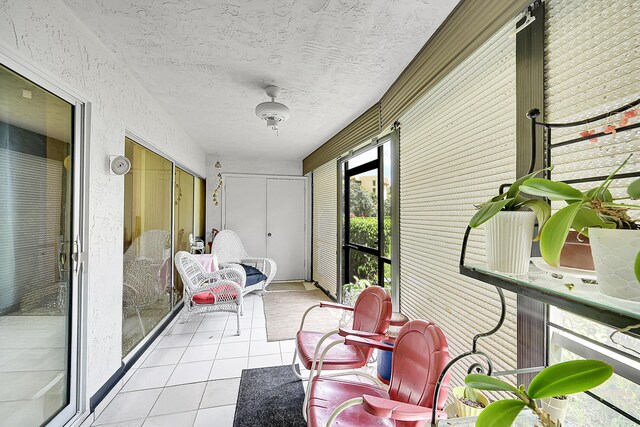 sunroom / solarium featuring tile patterned floors and a textured ceiling