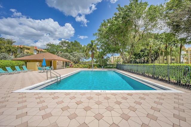 pool with a patio area and fence