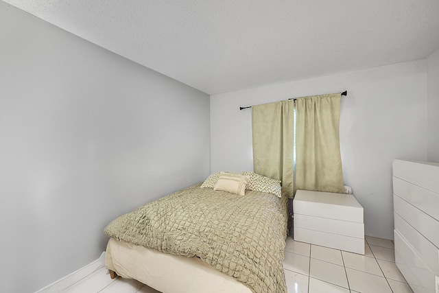 bedroom with baseboards and light tile patterned flooring