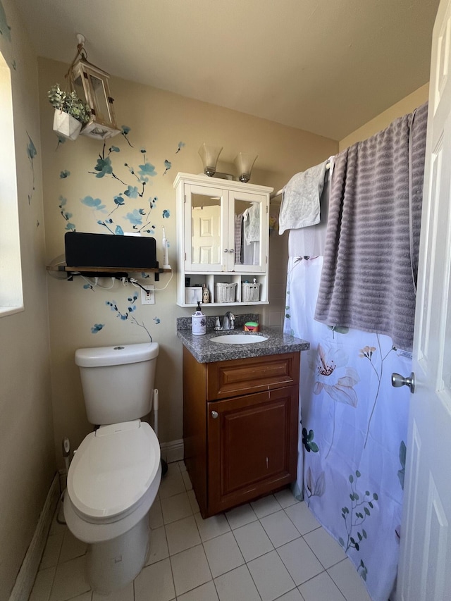 bathroom with tile patterned floors, vanity, baseboards, and toilet