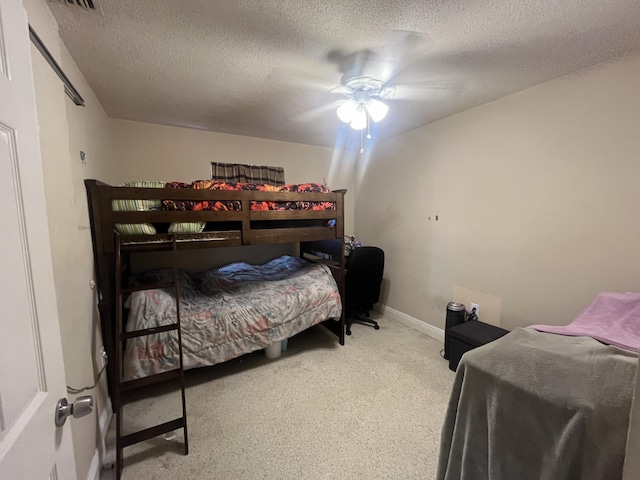 carpeted bedroom with a ceiling fan and a textured ceiling