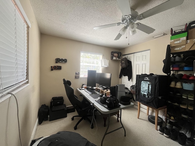 office with a textured ceiling, baseboards, a ceiling fan, and carpet floors
