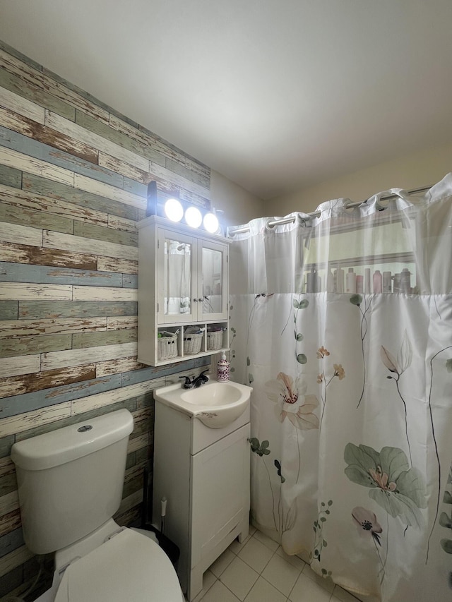 bathroom with vanity, tile patterned floors, a shower with curtain, toilet, and wood walls