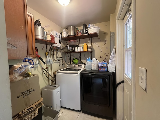 washroom with laundry area, washing machine and clothes dryer, and light tile patterned floors