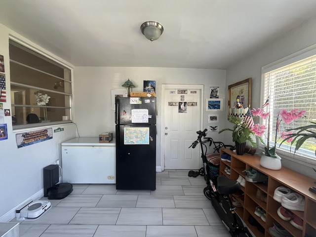 kitchen with white refrigerator, freestanding refrigerator, and baseboards